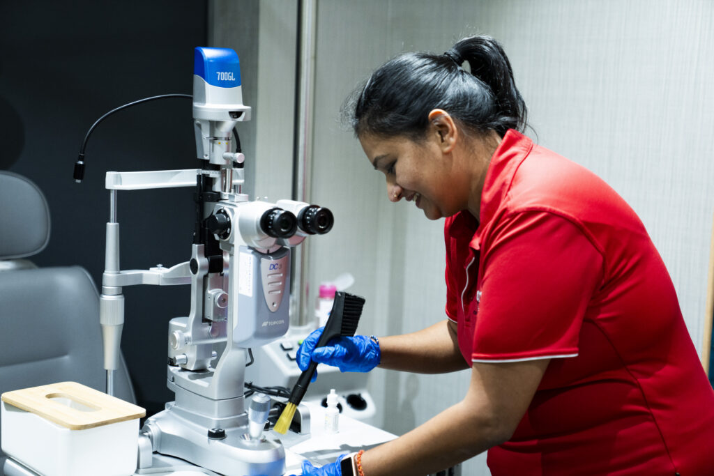 Professional AMC cleaner in uniform sanitising high-touch surfaces in a medical office using hospital-grade disinfectants. medical clinic treatment room in Dallas-Fort Worth.