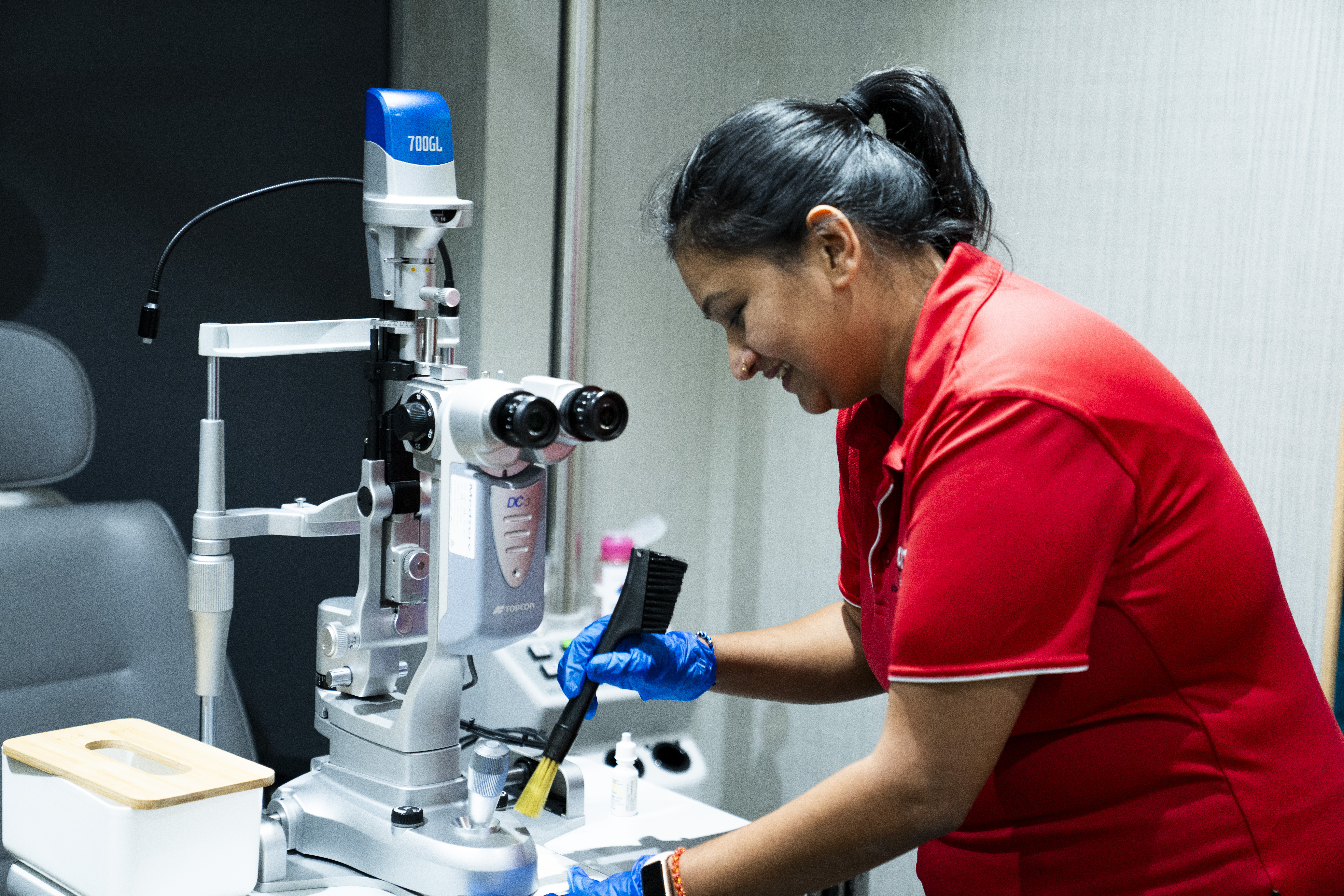 Professional AMC cleaner in uniform sanitising high-touch surfaces in a medical office using hospital-grade disinfectants. medical clinic treatment room in Dallas-Fort Worth.